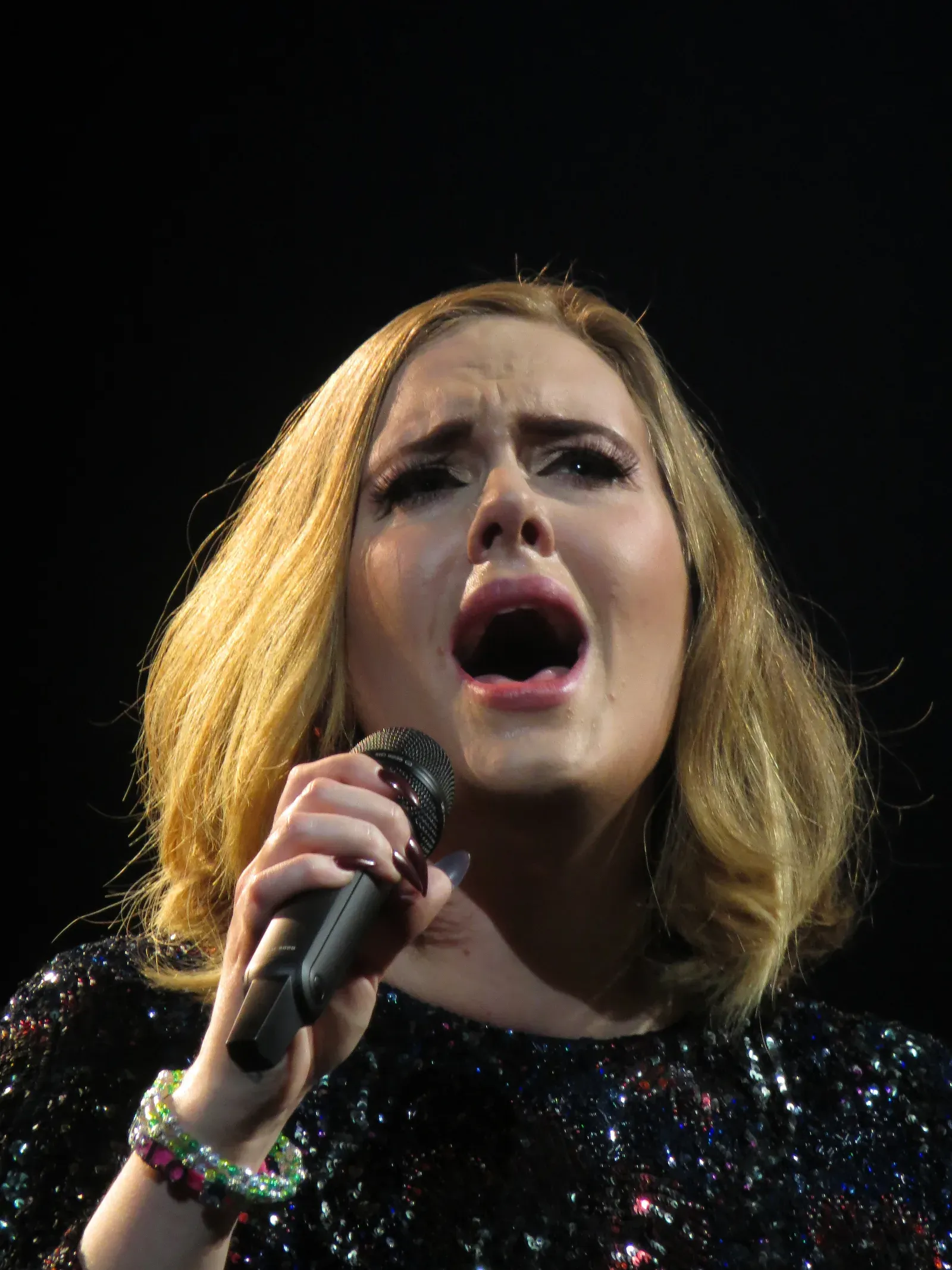 Adele en concert, chantant dans un micro à main