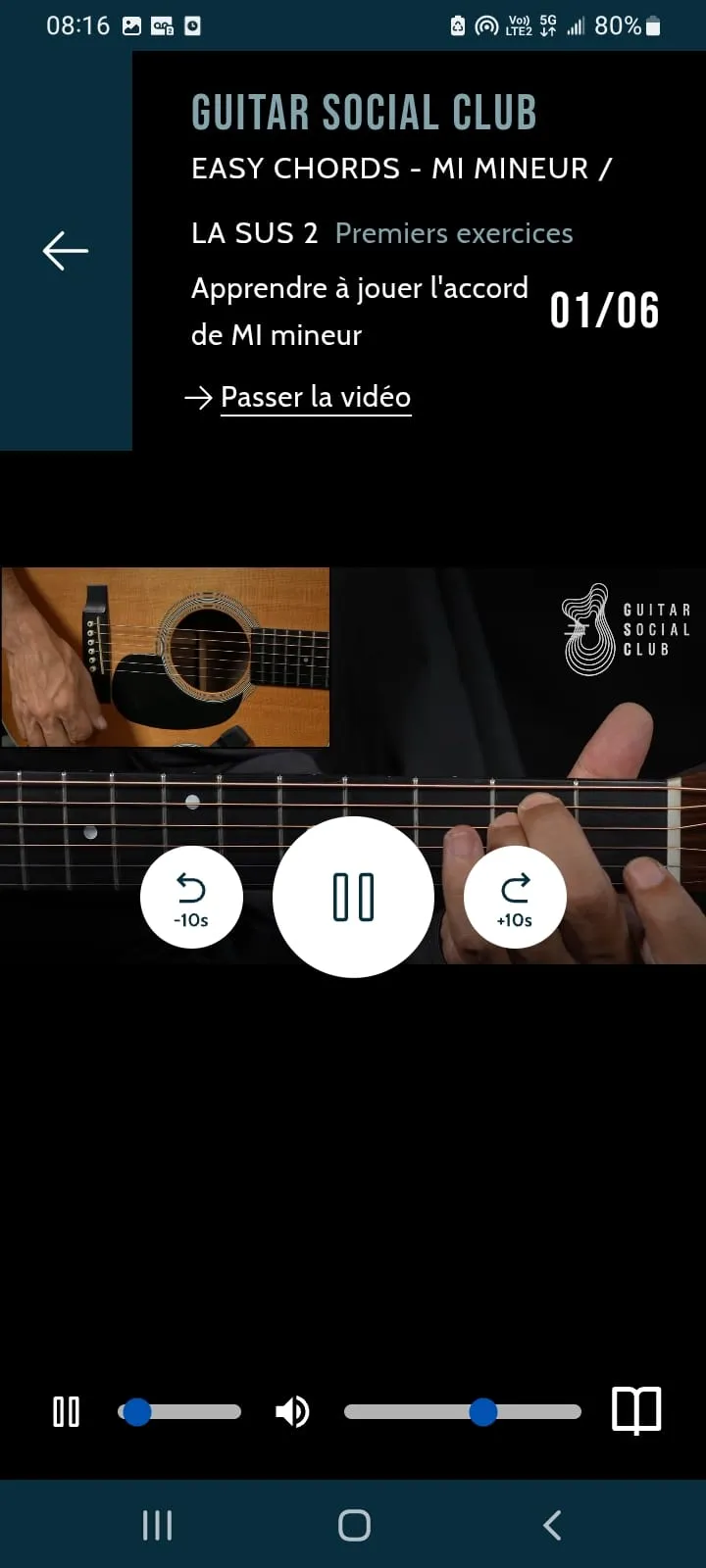 Lecteur vidéo de l'app Guitar Social Club : manche en gros plan, repères moins 10 secondes et plus 10 secondes, icône livre en bas à droite