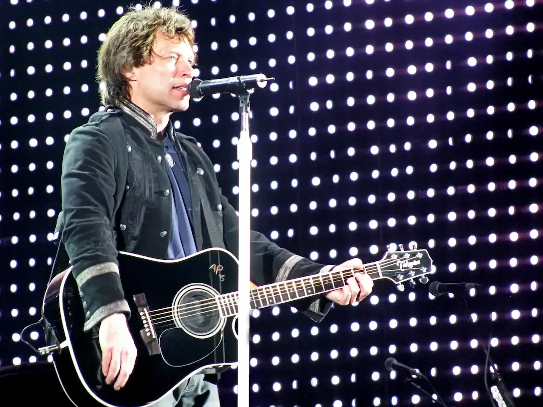 Bon Jovi en concert, guitare acoustique en main, sur scène pour l'album Slippery When Wet