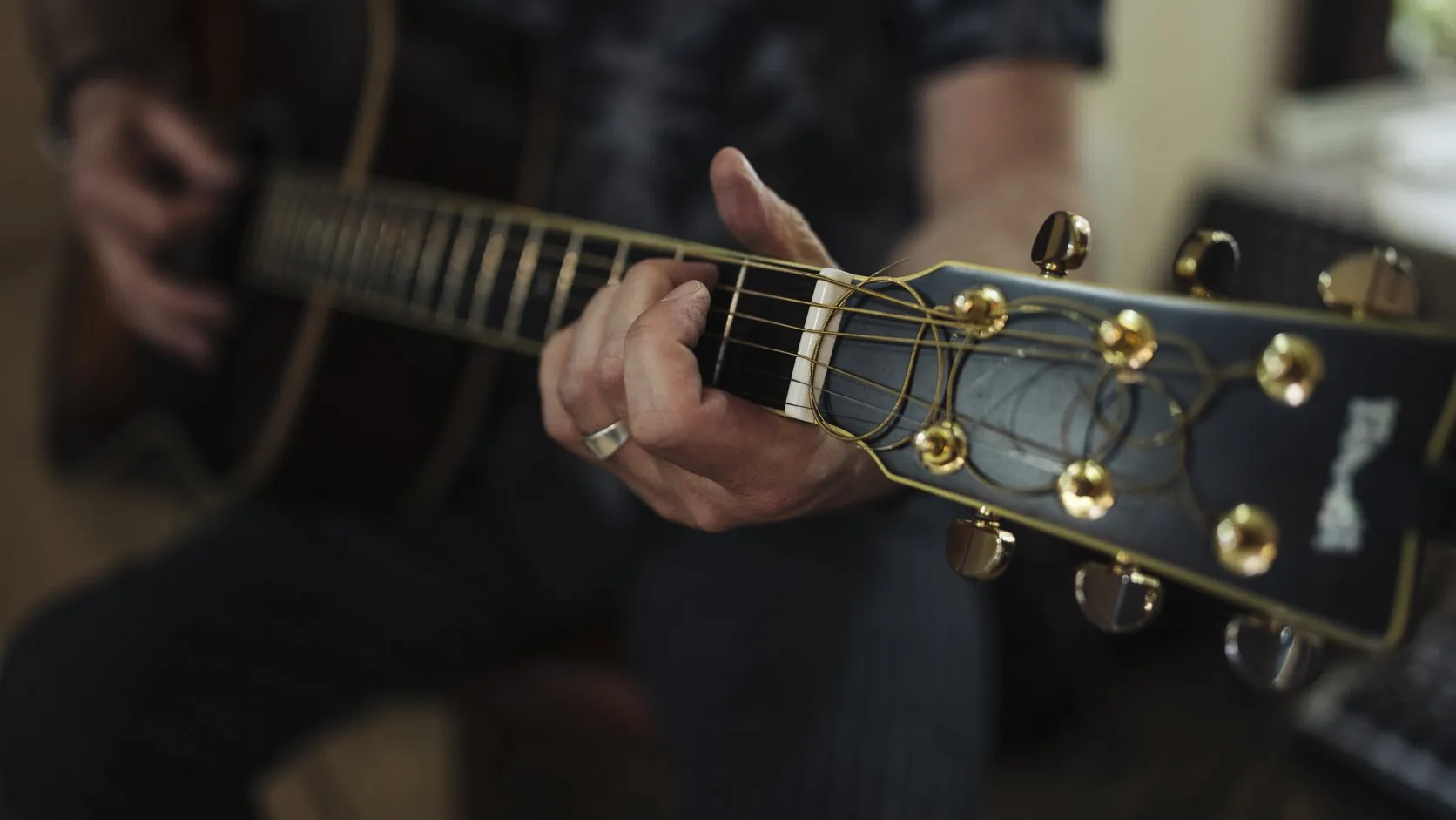 Adulte travaillant la guitare chez lui avec un plan de travail clair