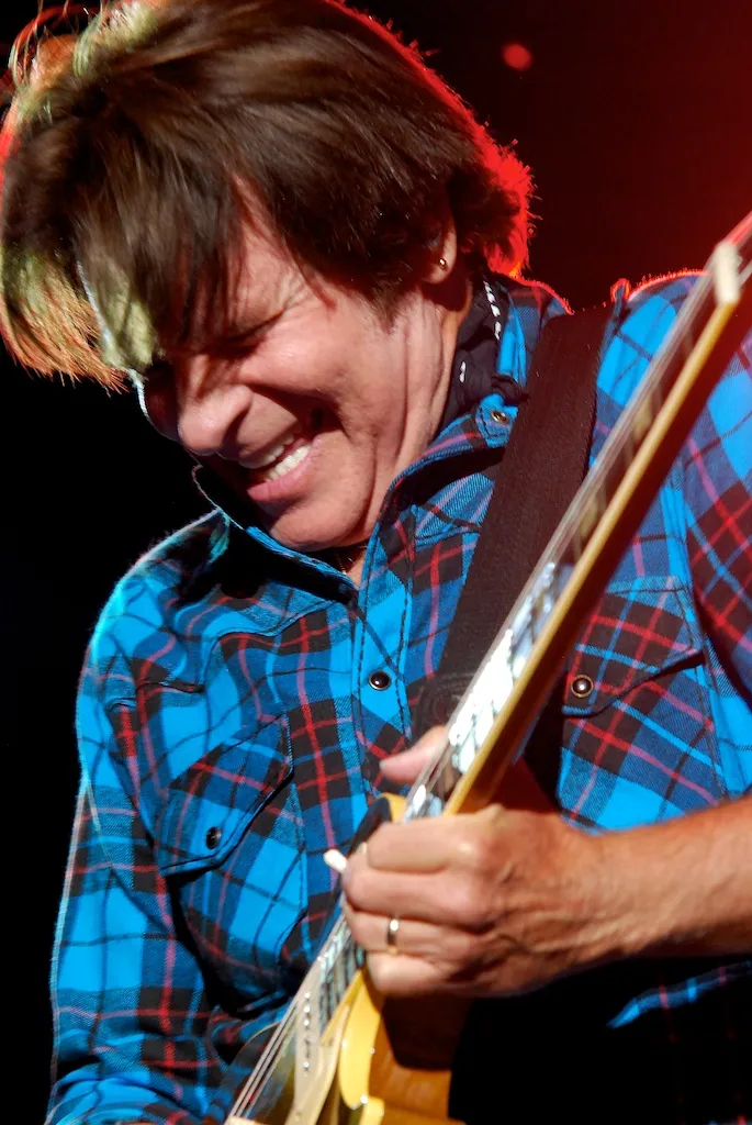 John Fogerty sur scène à la guitare, symbole du son roots rock de Creedence Clearwater Revival.