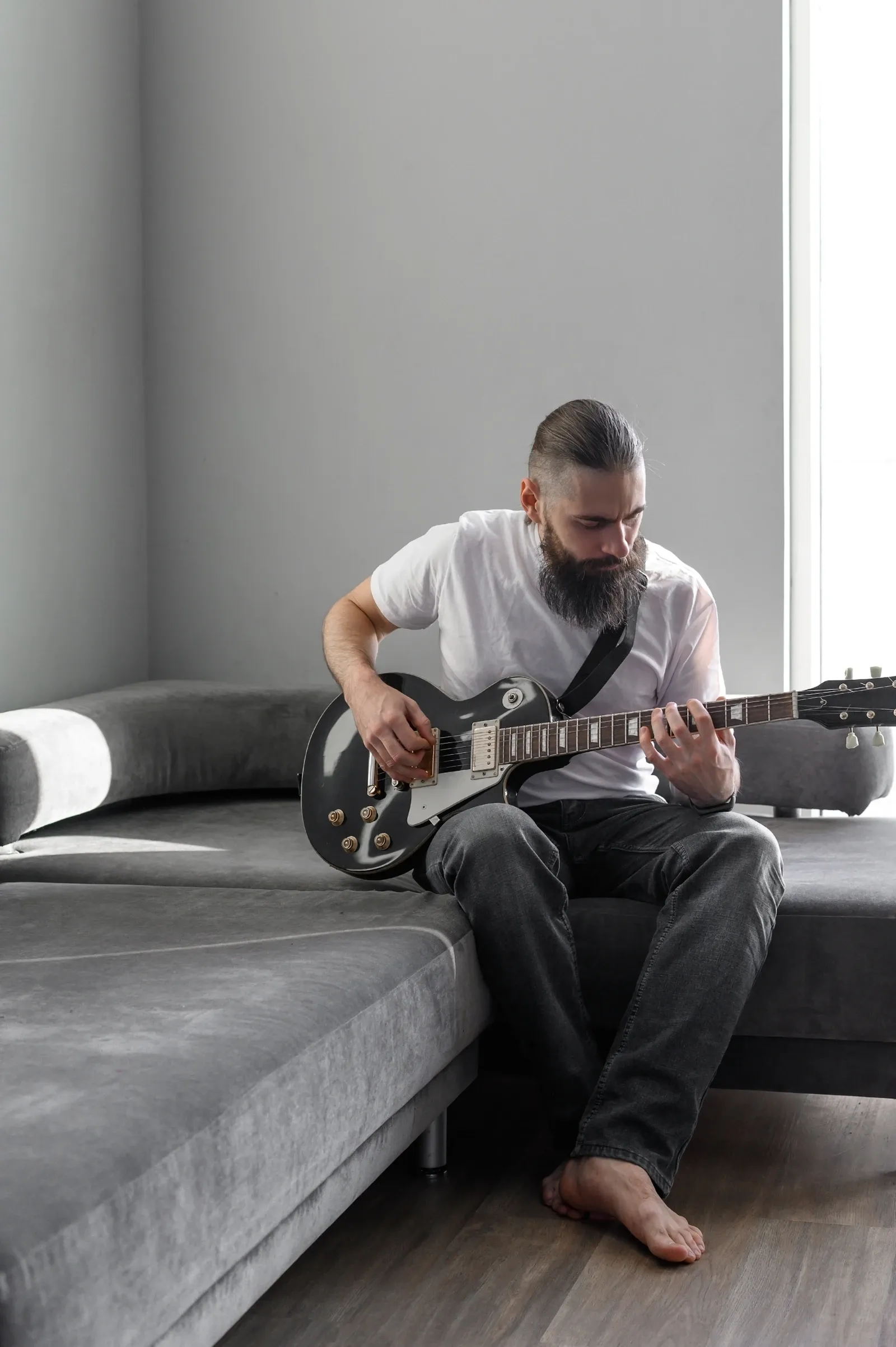 Guitariste adulte travaillant le rythme lentement chez lui
