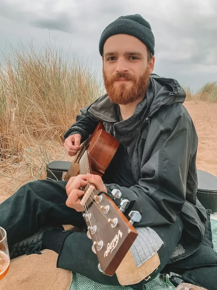 Moment de guitare acoustique en pleine nature sur la plage