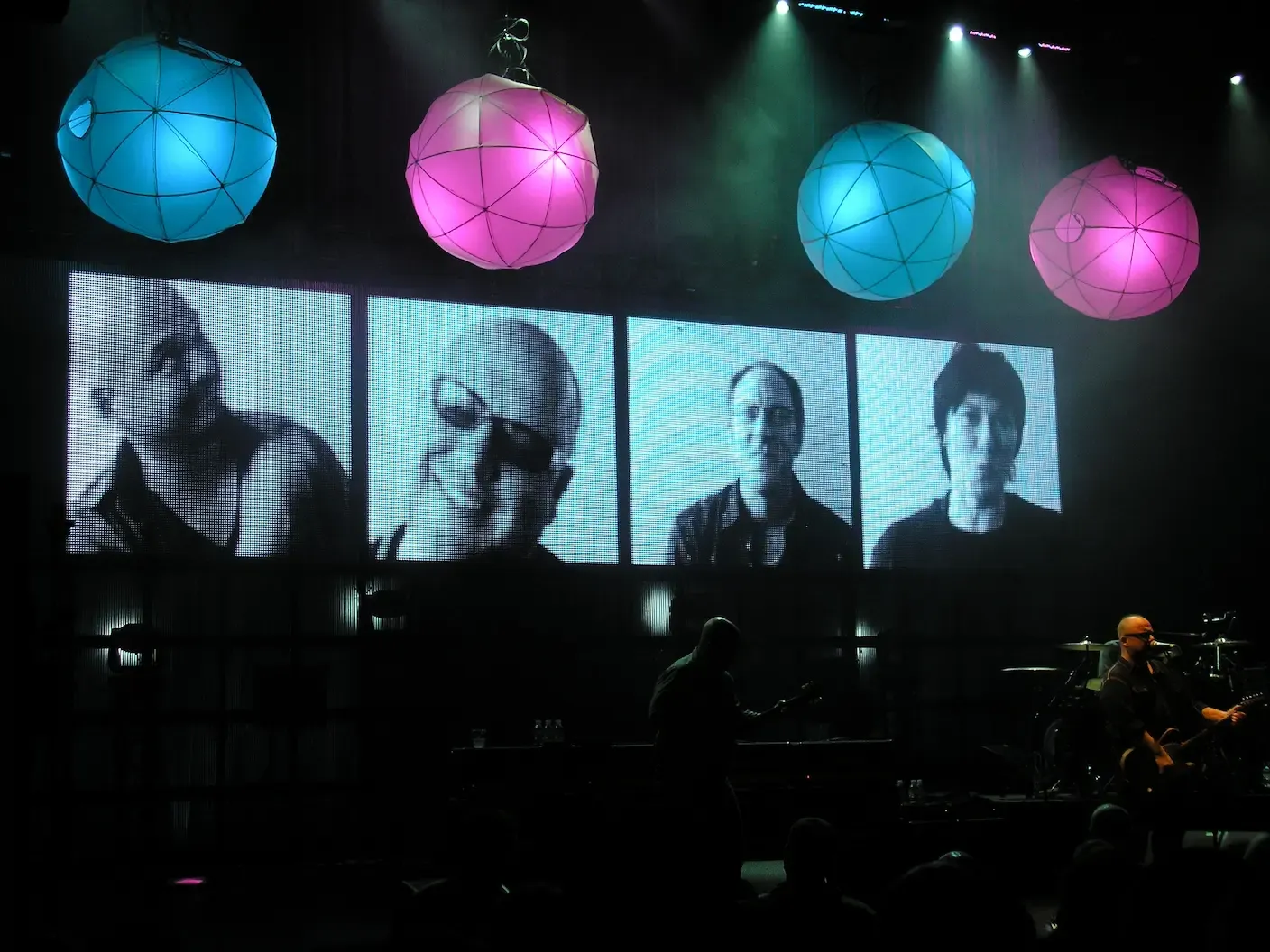 The Pixies en concert avec visuels des membres du groupe projetés sur écran