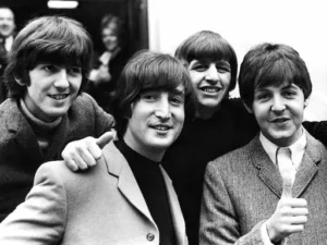 George Harrison, John Lennon, Ringo Starr et Paul McCartney souriants sur une photo emblématique des Beatles