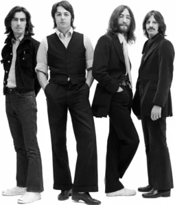 Les quatre membres des Beatles posant en studio, habillés en noir et blanc