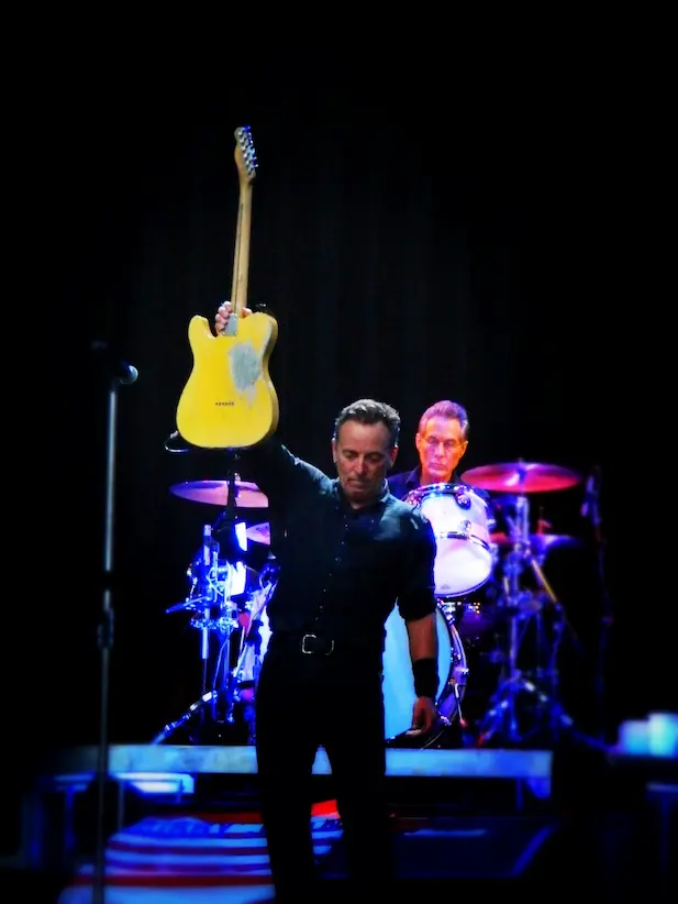 Bruce Springsteen en concert jouant de la guitare