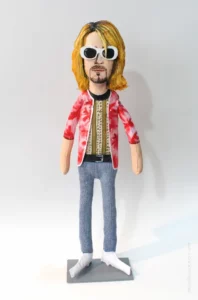Figurine de Kurt Cobain avec veste rouge et lunettes blanches