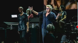 The Who en concert, avec le chanteur au micro et les musiciens jouant sur scène devant le public.