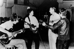 Les Beatles en studio avec George Martin en 1966, travaillant sur un enregistrement.