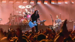 Le groupe Foo Fighters en concert avec Dave Grohl à la guitare, accompagné du batteur et du bassiste, devant un public enthousiaste