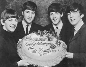 Les Beatles tenant un gâteau avec un message pour la Suède.