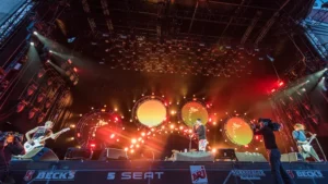 Les Red Hot Chili Peppers en concert sur une grande scène illuminée.
