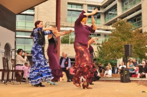 Danseuses de flamenco en plein mouvement sur scène lors d’un spectacle en plein air, accompagnées de musiciens, pour une interprétation festive de Volare des Gipsy Kings.